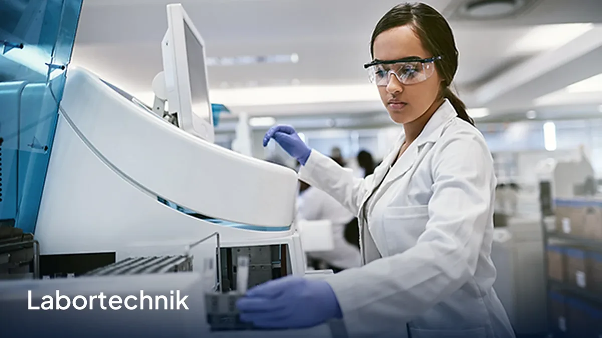 Anwendungsfeld Labortechnik: Laborantin mit Schutzbrille an einem Analysegerät.