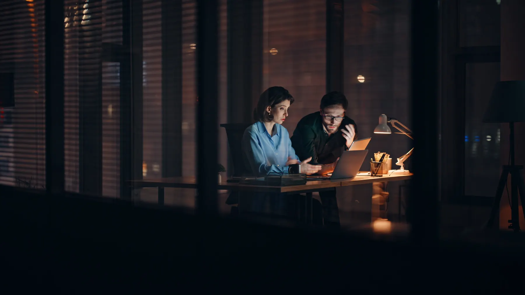 Zwei Kollegen arbeiten abends im Büro