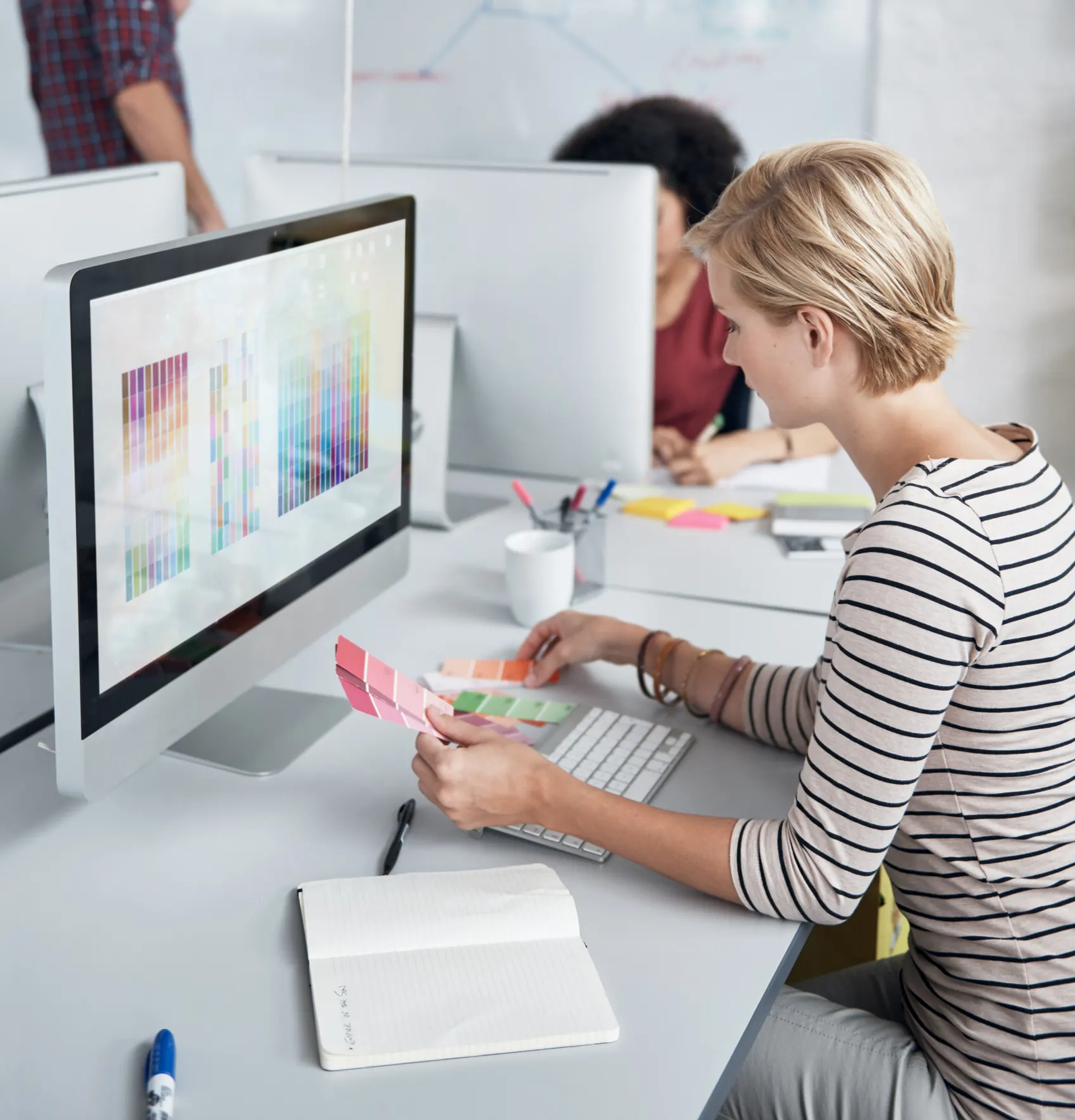 Designerin prüft Farbmuster am Bildschirm